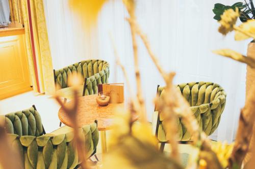 a room with green chairs and a table in front of a mirror at Park Hotel Laim in Munich