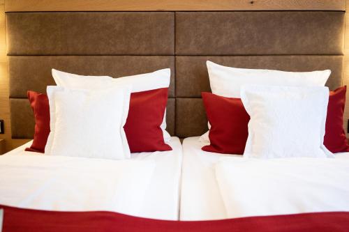 a bedroom with two beds with red and white pillows at Park Hotel Laim in Munich