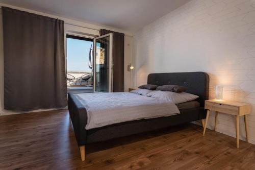 Un dormitorio con una cama y una ventana grande. en Apartmán pod Vežou 2, en Banská Bystrica