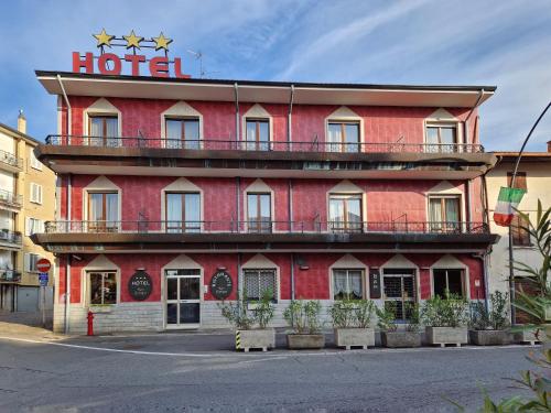 een rood gebouw met een hotelbord erop bij Hotel San Giorgio in Boltiere