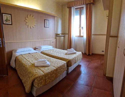 twee bedden in een hotelkamer met handdoeken erop bij Hotel San Giorgio in Boltiere