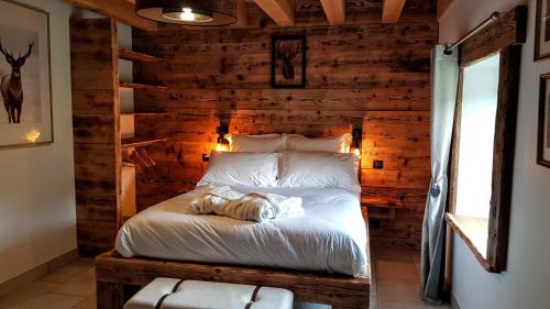 une chambre avec un lit dans un mur en bois dans l'établissement Joli chalet 12 personnes 200m2 sauna baby-foot, à Cleurie