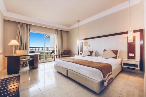 Habitación de hotel con cama grande y escritorio. en Iberostar Selection Royal El Mansour en Mahdia