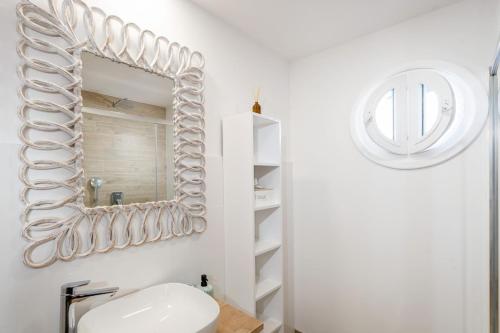 uma casa de banho branca com um espelho e um lavatório em Apartmán pod Vežou 1 em Banská Bystrica