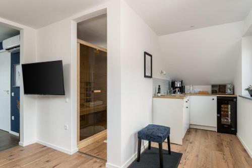 a living room with a tv and a kitchen at Kapocs Apartmanház in Borgáta