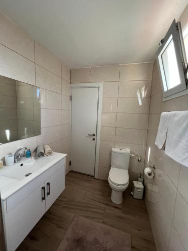 a bathroom with a toilet and a sink and a mirror at HAWAII in Eilat