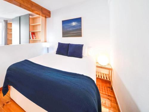 - une chambre dotée d'un grand lit blanc avec des draps bleus dans l'établissement Apartamento Mercaderes, à Pampelune