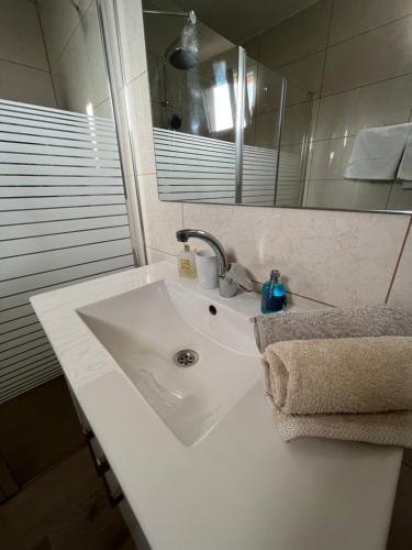 La salle de bains est pourvue d'un lavabo blanc et d'un miroir. dans l'établissement HAWAII, à Eilat