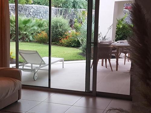 a room with a sliding glass door with a chair on a patio at Palmmar Jardines NEW 2bedroom ISORA 0,4 Appt 105m2 with garden in Palm-mar
