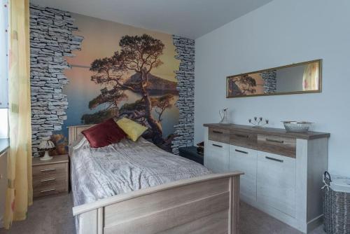 ein Schlafzimmer mit einem Baumbild an der Wand in der Unterkunft Schöne lichtdurchflutete Ferienwohnung mit Balkon in Hagen
