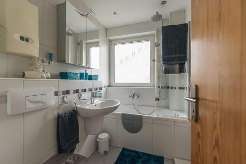 ein Bad mit einem Waschbecken, einem WC und einem Fenster in der Unterkunft Schöne lichtdurchflutete Ferienwohnung mit Balkon in Hagen