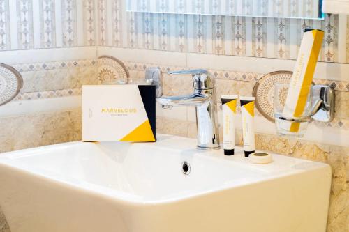 - un lavabo blanc avec une boîte en haut dans l'établissement فندق ركاز الماسي - Rekaz Diamond Hotel, à Sīdī Ḩamzah
