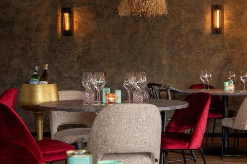 a restaurant with tables and chairs with wine glasses at Hotel Four in Geldrop