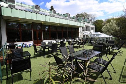 a group of tables and chairs in front of a building at Panorama Hotel Noszvaj in Noszvaj