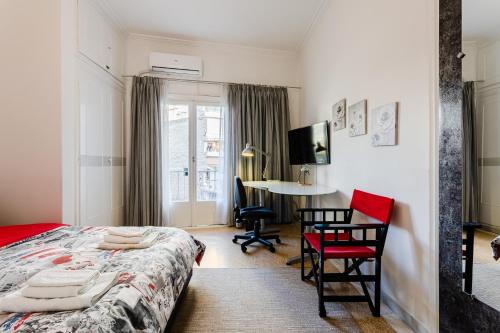 1 dormitorio con 1 cama, mesa y sillas en Mets en Athens