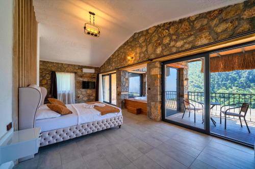 1 dormitorio con 1 cama y balcón en 2 Bedroom Private Villa with great sea view en Faralya