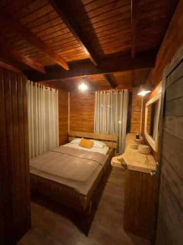 ウルラにあるPanurla Wooden House havuz & sauna kırmızıの木製の部屋にベッド1台が備わるベッドルーム1室があります。