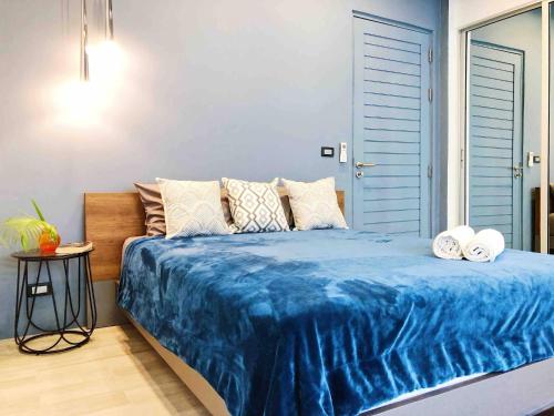 a bed with a blue comforter in a bedroom at Contemporary 3bd Safari Pool Villa Near Nai Yang Beach in Ban Bo Han