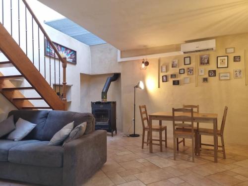 a living room with a couch and a table and chairs at Gîte "La Cachette"- Mirmande - in Mirmande