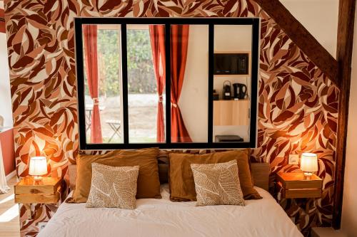 a bedroom with a large mirror above a bed at La Maison de Maxou in Montauban