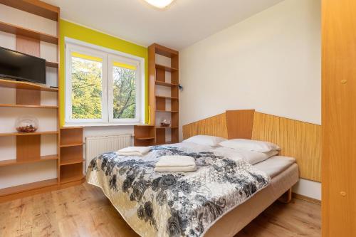 a bedroom with a bed and a window at Rezydencja Spacerowa Apartamenty by Renters in Kołobrzeg