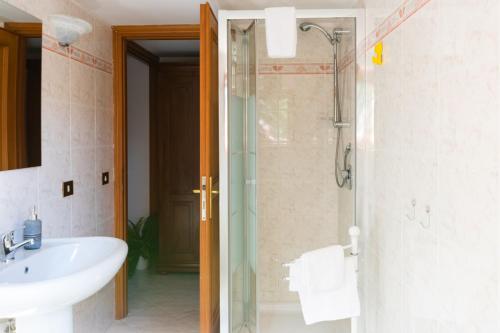 a bathroom with a sink and a glass shower at Casa delle Arance in Acilia