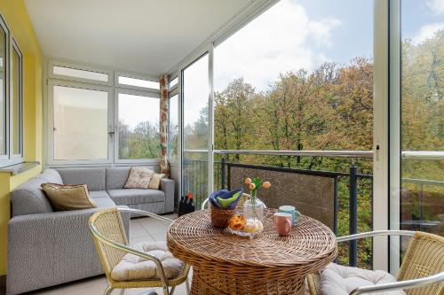 a screened in porch with a table and chairs at Rezydencja Spacerowa Apartamenty by Renters in Kołobrzeg