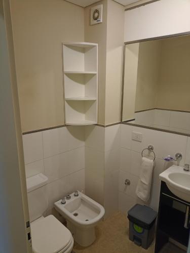 y baño con lavabo, aseo y espejo. en Edificio NEA en Corrientes