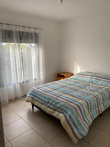 una camera da letto con un letto con un piumone a righe e una finestra di Luis II a Villa María