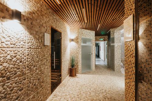 a hallway with brick walls and a wooden ceiling at Orava Village in Oravská Lesná