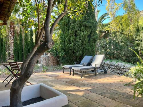 two chairs and a tree sitting on a patio at Hotel Finca Ca N'ai - Adults Only in Sóller