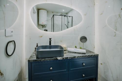 W łazience znajduje się niebieska umywalka i lustro. w obiekcie VisitZakopane - Szarotka Apartment w Zakopanem