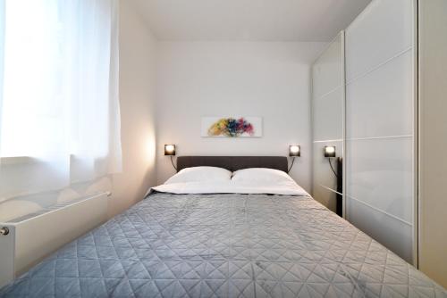 ein kleines Schlafzimmer mit einem Bett mit weißen Wänden in der Unterkunft Ophelia Apartment with parking in Zagreb
