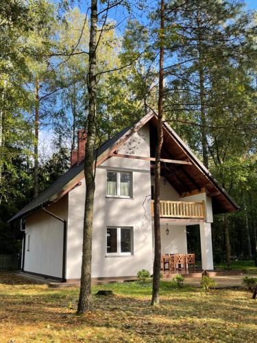 a white house with a gambrel roof at Leśnisko in Jerutki