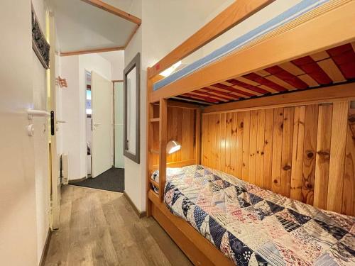 - une chambre avec un lit et un mur en bois dans l'établissement Charmant 2 pièces cabine, balcon, parking, navette, wifi gratuit, proche commerces et pistes, 4 pers - FR-1-525-242, à Saint-Étienne-en-Dévoluy