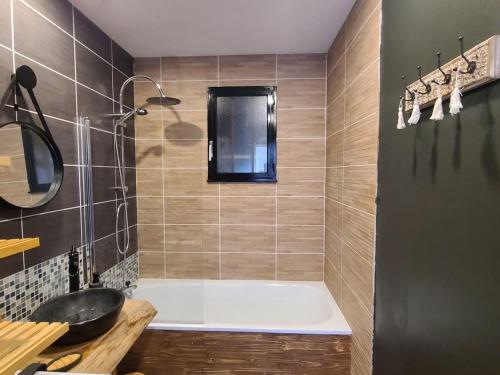 a bathroom with a bath tub and a sink at Gîte La Vôge-les-Bains, 3 pièces, 4 personnes - FR-1-589-418 in Harsault