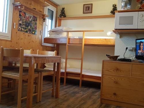 a room with a bunk bed and a table and a desk at Appartement Le Pleynet, 1 pièce, 3 personnes - FR-1-557A-51 in La Ferrière