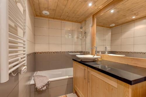 ein Badezimmer mit Badewanne, Waschbecken und Badewanne Tubermottermott in der Unterkunft Chalet des Oursons in Cohennoz