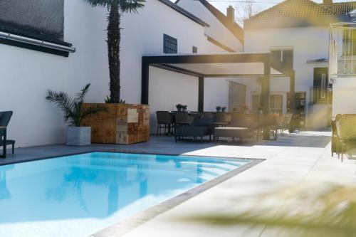 a swimming pool in the middle of a patio with a table at KRACHER Guesthouse No 7 in Illmitz