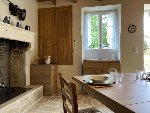 cocina con mesa de madera y chimenea en Gîte Val-de-Bonnieure, 3 pièces, 4 personnes - FR-1-653-214, 
