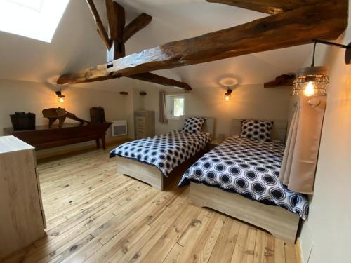 的住宿－Gîte Val-de-Bonnieure, 3 pièces, 4 personnes - FR-1-653-214，铺有木地板的客房内的两张床