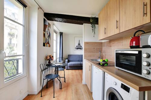 une petite cuisine avec une table et un micro-ondes dans l'établissement Studio in the heart of the Marais !, à Paris