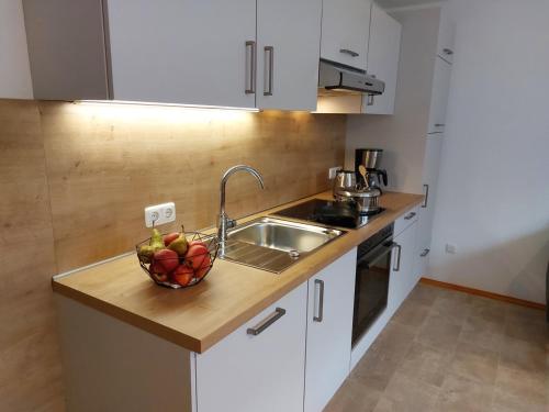a kitchen with a sink and a bowl of fruit at Ferienwohnung Gaul in Riedenburg
