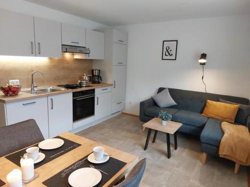 a kitchen and a living room with a couch and a table at Ferienwohnung Gaul in Riedenburg