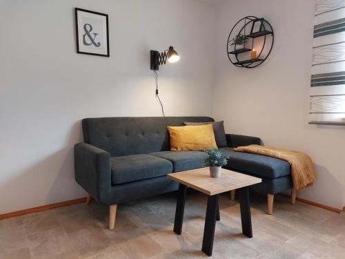 a living room with a blue couch and a table at Ferienwohnung Gaul in Riedenburg