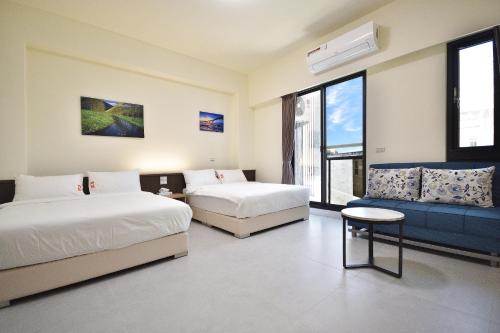 une chambre d'hôtel avec deux lits et un canapé dans l'établissement v2民宿, à Taïtung