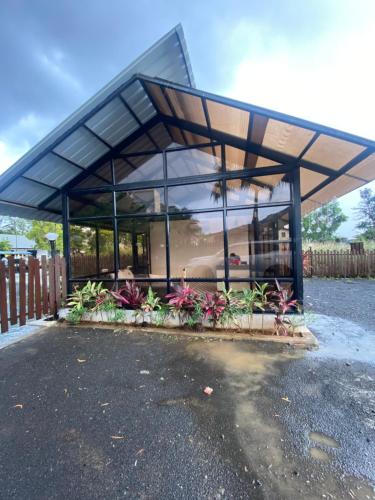 a building with a glass roof with flowers in front at GLASS HOUSE with private pool in Lonavla in Lonavala
