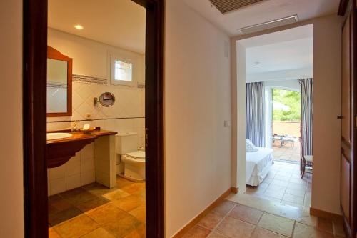 a bathroom with a sink and a toilet in a room at Hotel Cala Sant Vicenç - Adults Only in Cala de Sant Vicenc