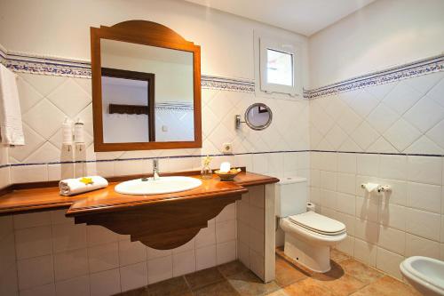 a bathroom with a sink and a toilet and a mirror at Hotel Cala Sant Vicenç - Adults Only in Cala de Sant Vicent