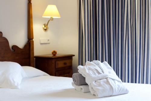 a hotel room with a bed with towels on it at Hotel Cala Sant Vicenç - Adults Only in Cala de Sant Vicent